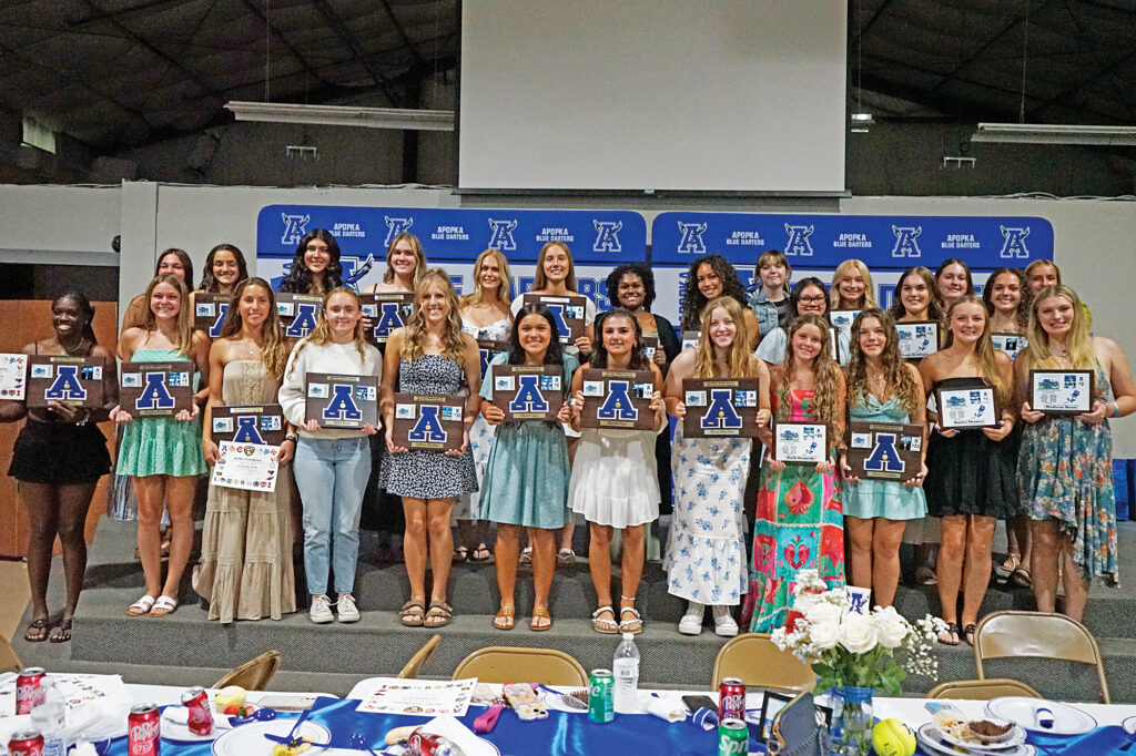 The Apopka JV and varsity softball teams stand together with their plaques after the banquet on Tuesday, May 27.