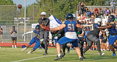 Wekiva’s quarterback gets a pass off just in time as a Lyman defensive end wraps around his leg after breaking into the pocket.