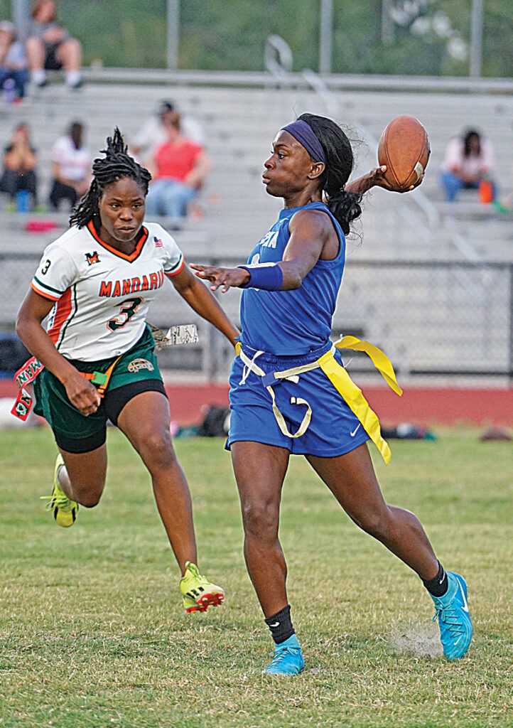 Jhenelle Francis winds up for a throw as an incoming pass rusher attempts to sack her.