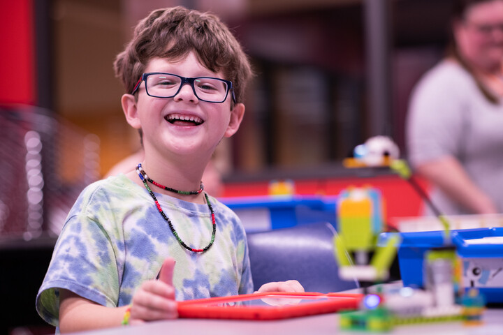 Young boy smiles at an April 2023 event hosted by OCLS.