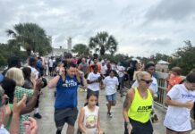 A group of people in workout clothes jog outdoors in a race.