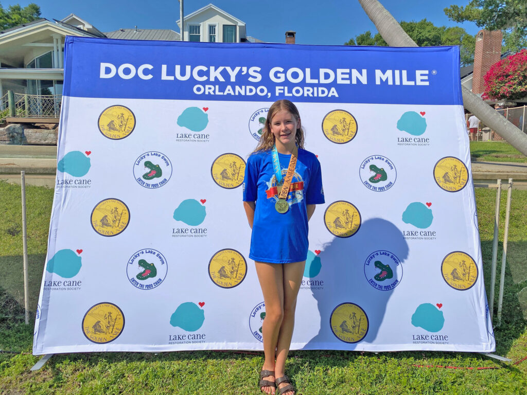 Keira Druck stands with her award after finishing fifth overall in The Golden Mile Swim.