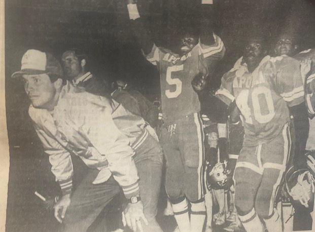 Coach Chip Gierke watches a play finish while players of his celebrate.