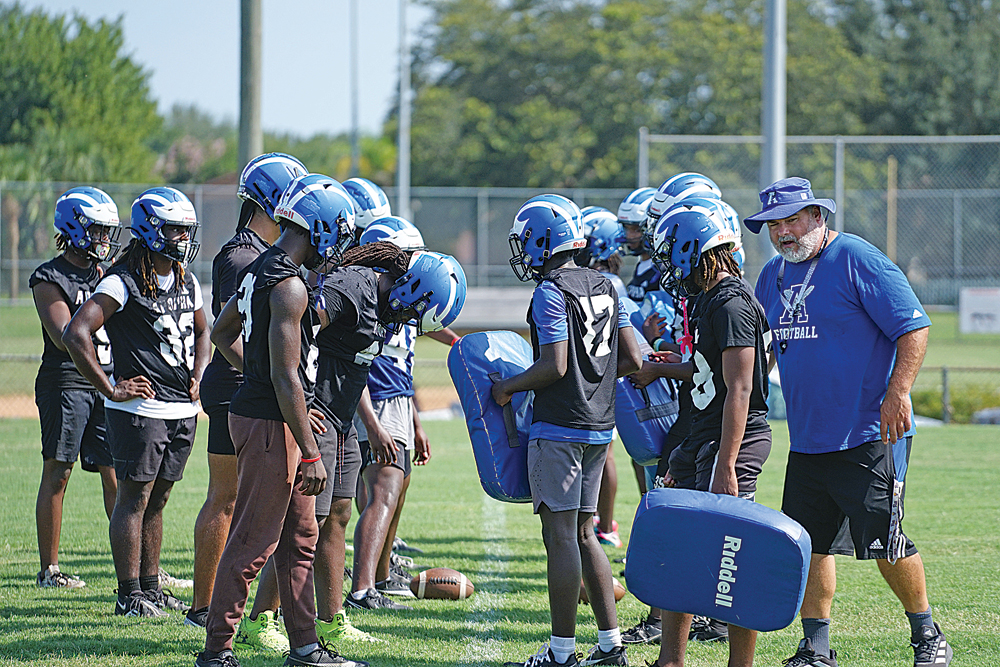 Apopka football's previous head coach, Jeff Rolson, talks with linebackers during a drill at spring practice.
