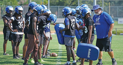Apopka football's previous head coach, Jeff Rolson, talks with linebackers during a drill at spring practice.