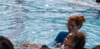 YMCA instructor teaches a little girl how to swim.