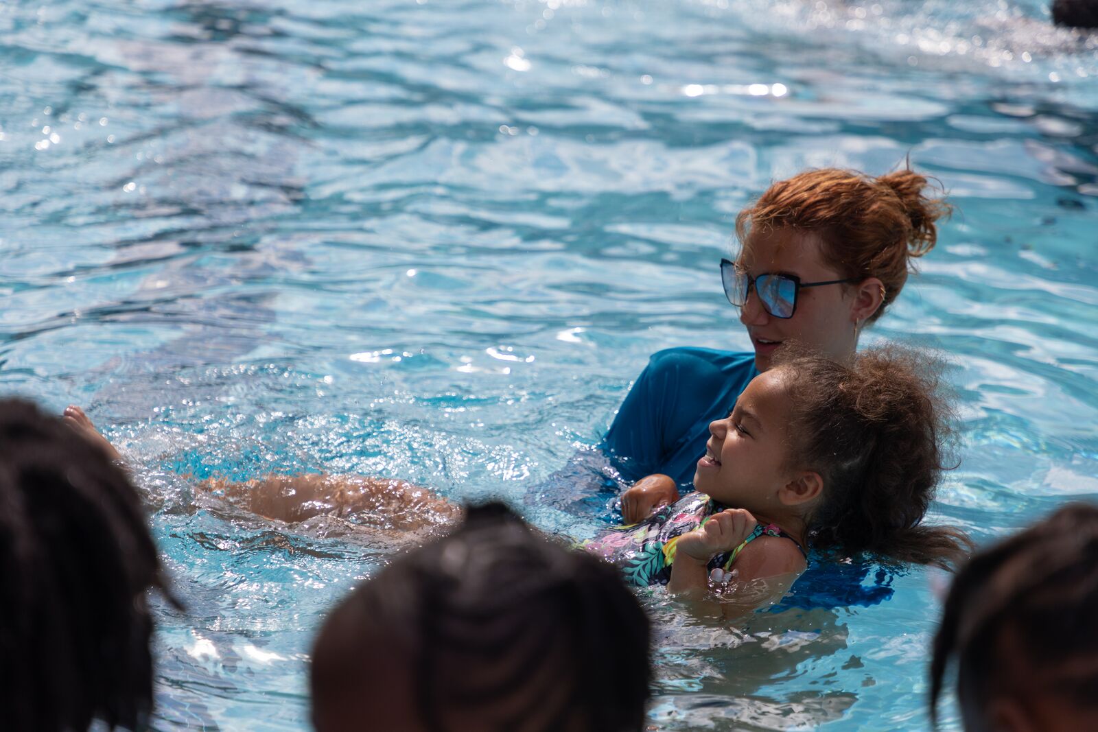 YMCA instructor teaches a little girl how to swim.