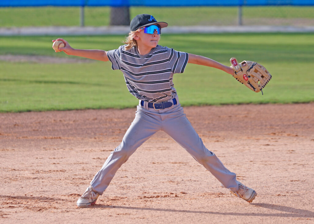 A member of Apopka Little League’s Majors All-Star team puts everything he has into a throw to first base.