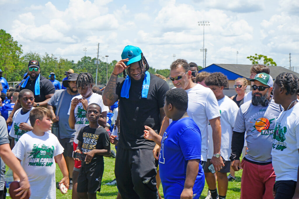 A photo of Super Bowl Champion Jalen Carter speaking with a young camper from his annual free skills camp.