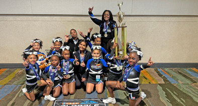Apopka Pop Warner's Cheer Coordinator, Sheronda Wright, stands with her Tiny Mites team after finishing first at the 2024 National competition.