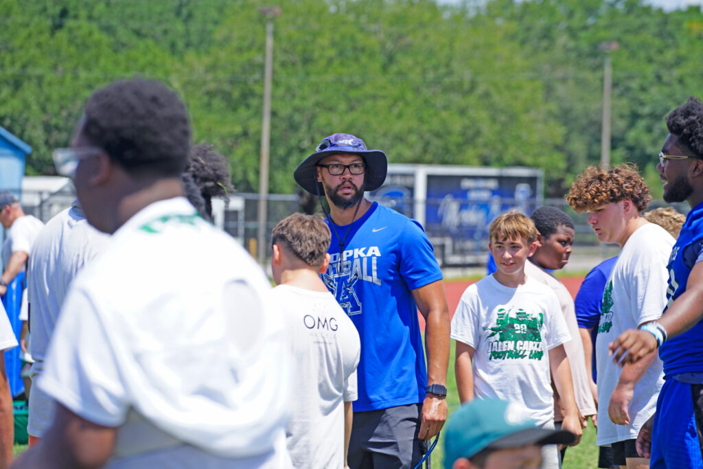 Marcus Neeson looks around Roger Williams Field at Apopka High School while surrounded by young campers.