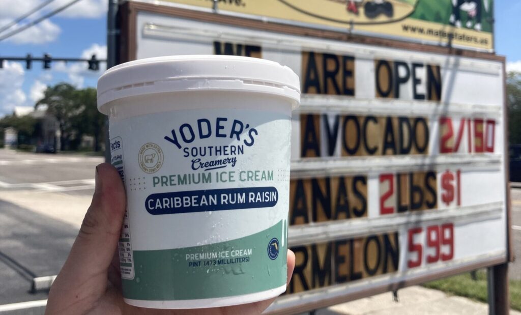 A pint of Caribbean rum raisin ice cream in front of the Maters & Taters sign