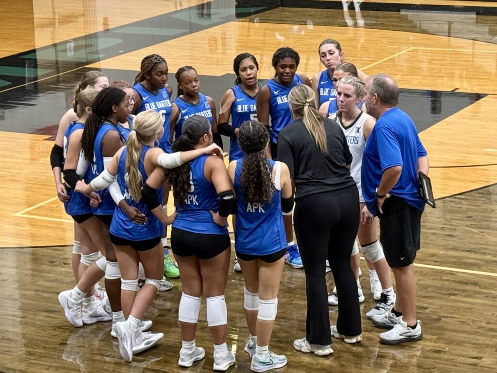 Blue Darters team huddle during the first set break.