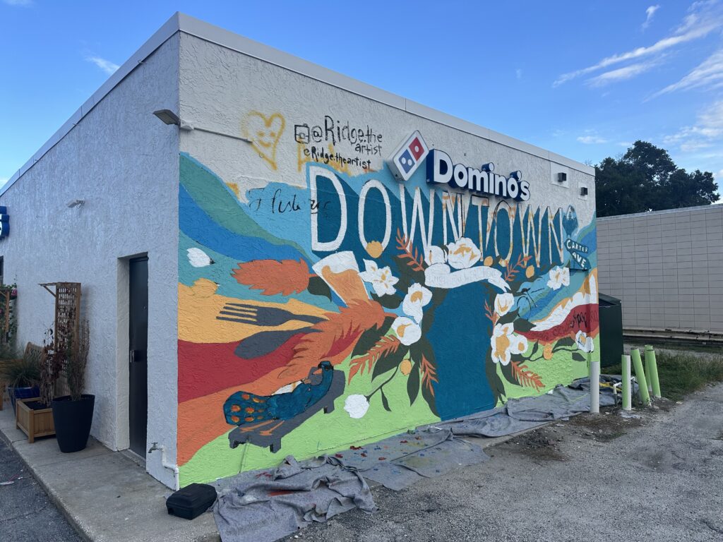The Downtown Mural on the west wall of the Domino’s Pizza East Main Street building is in progress.