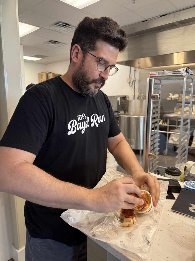 Operator Alex Casanova dips his pizza bagel in hot sauce cream cheese.