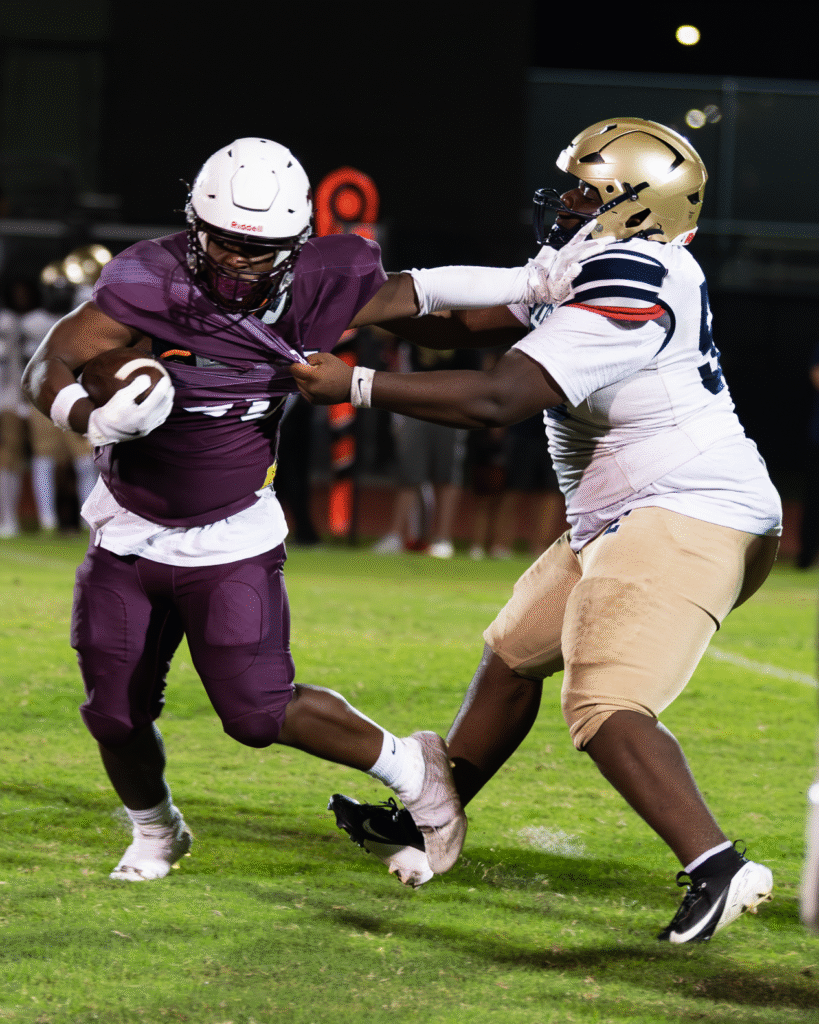 Isaiah Hollie hands out a big stiff arm.