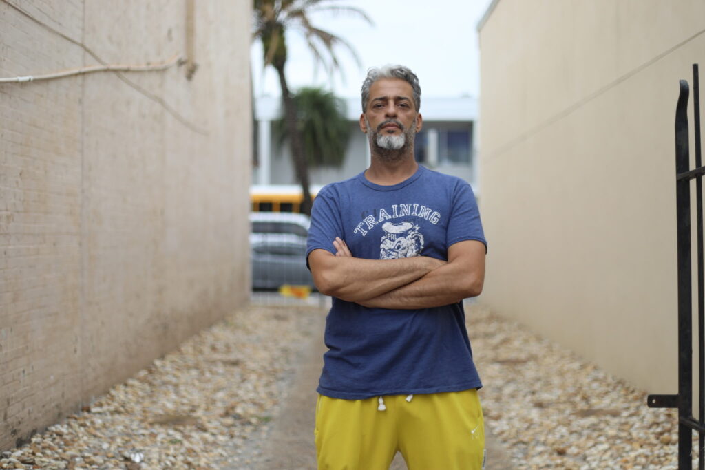 Luis Rivera poses in front of a passageway before transforming it into the Apopka Murals Downtown Art Walk.