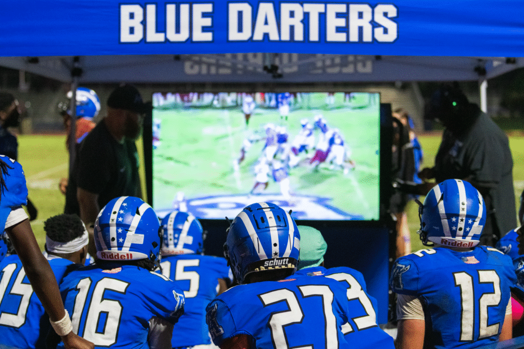 Blue Darters offense gather around the film board
