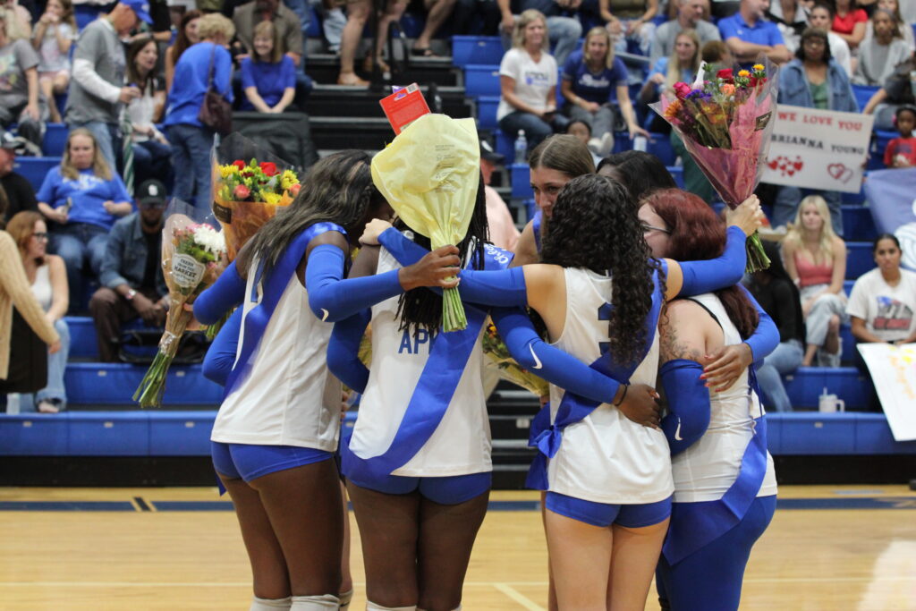 Seniors huddle up with their flowers after standing ovation