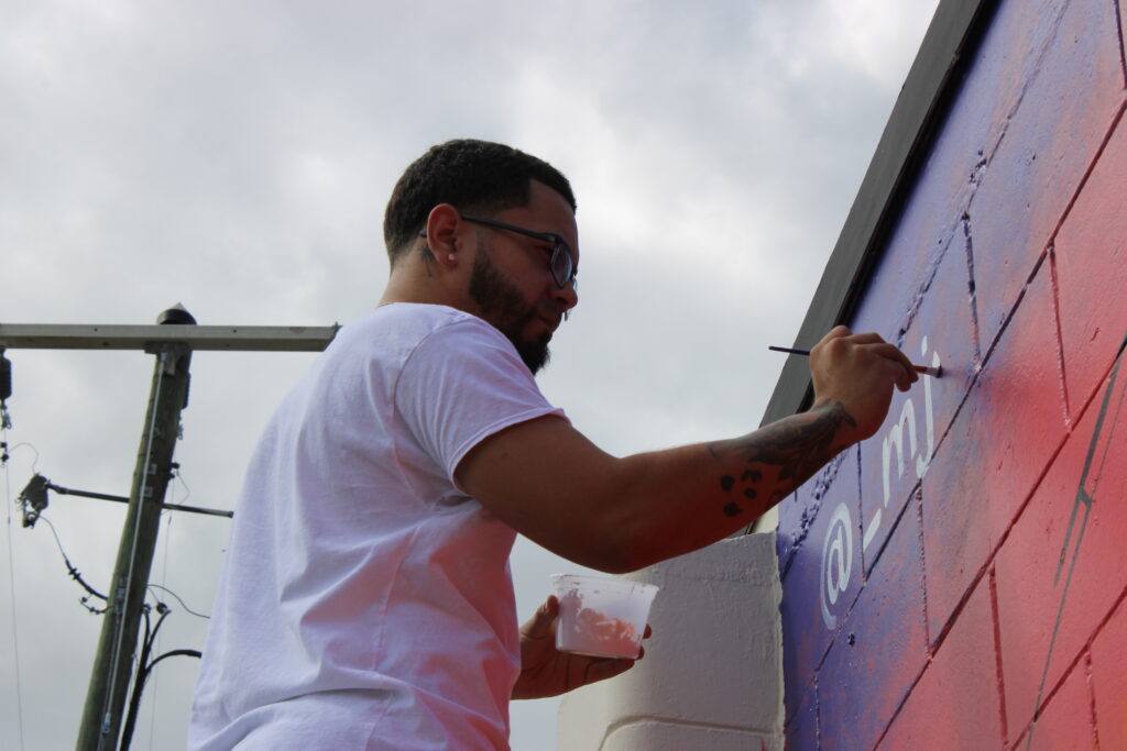 Michael "Maik" Delgado signs his Lake Apopka mural.