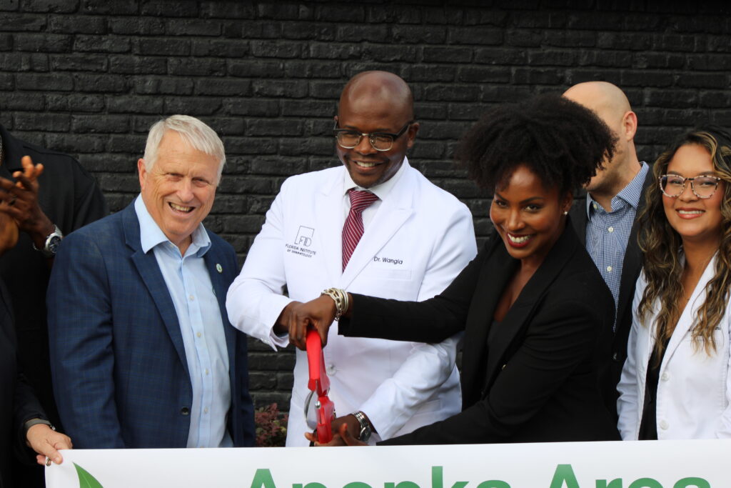 Mayor Bryan Nelson, Dr. Michael Wangia and Morgan Wangia cut the ribbon.