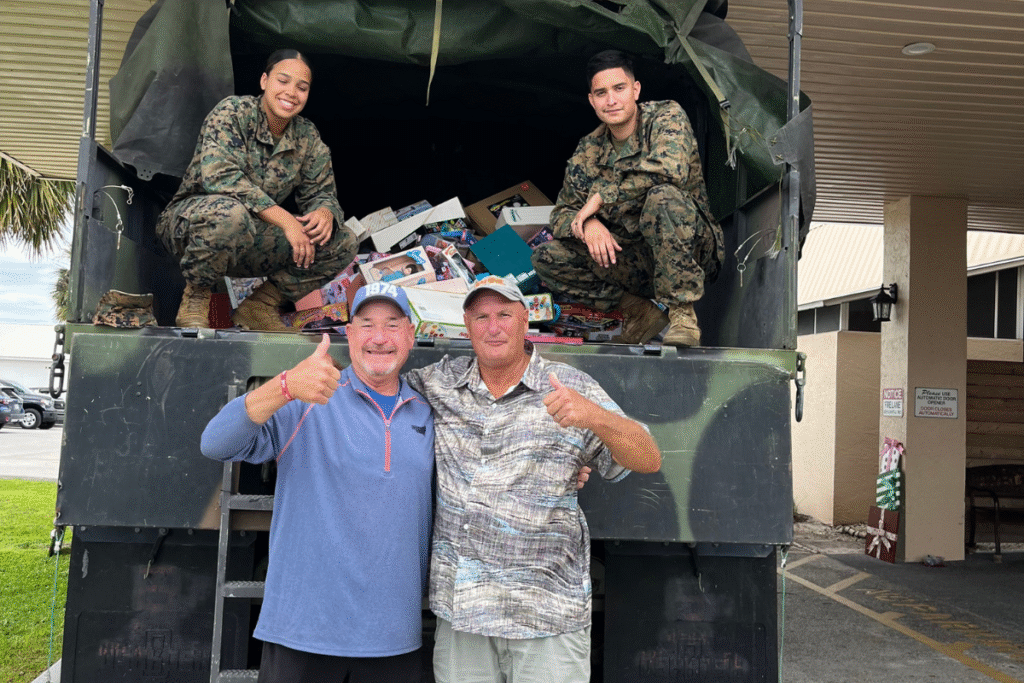 Derrel Dossett Jr. and Zellwood Station resident Larry Hoistion pose with the Marines who picked up last year's donations.