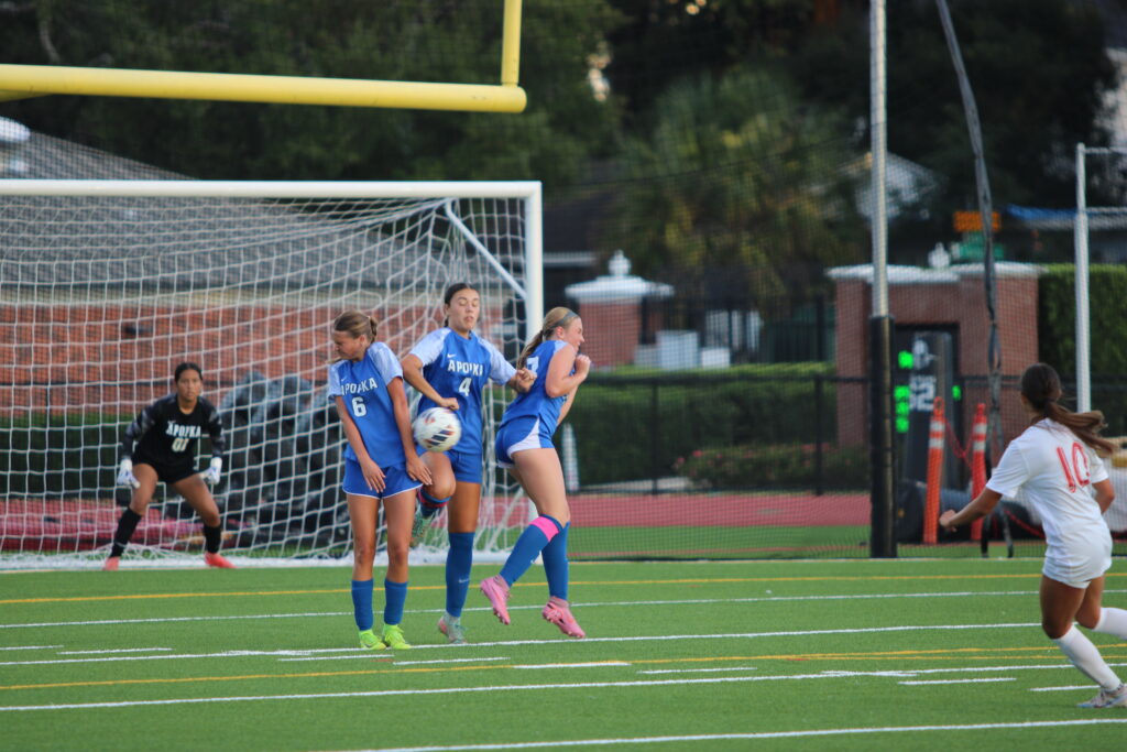 Presley Perrone, Neveah Nguyen, and Addison Kramer form a wall to block the short free kick