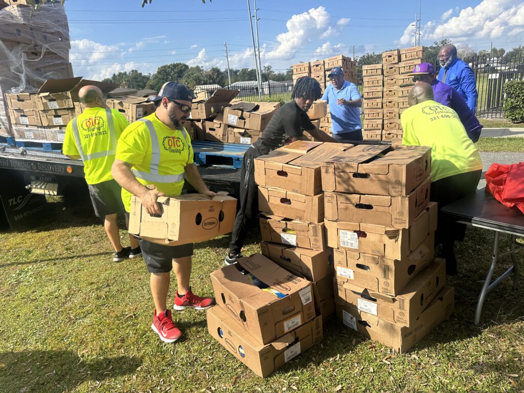 People unload boxes of turkeys from the back of a truck.