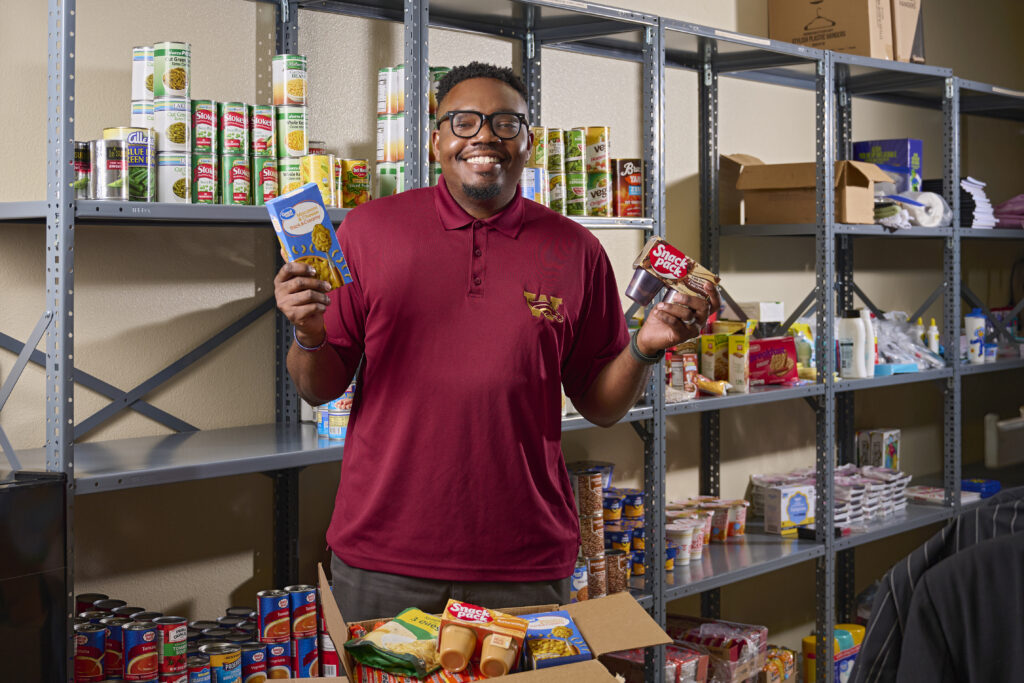 Johnny Outing holds up products that will stock the Mustang Market, a food pantry set to open next spring at Wekiva High School.