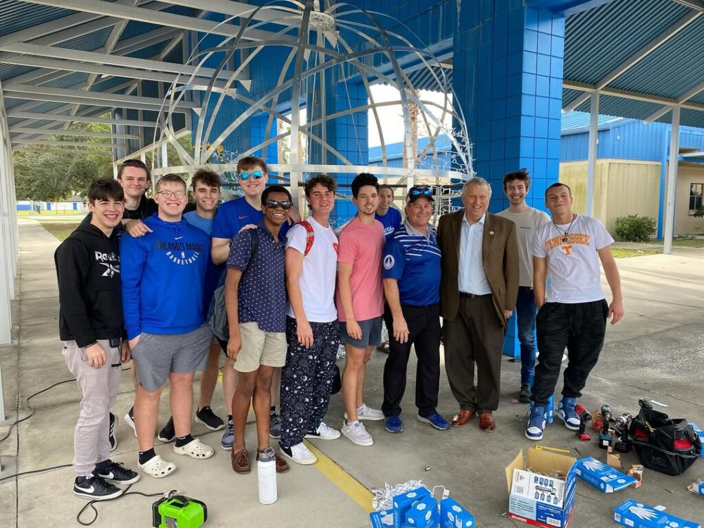 Apopka High School engineering students pose with Mayor Bryan Nelson while constructing the New Year's Eve ball in 2023.