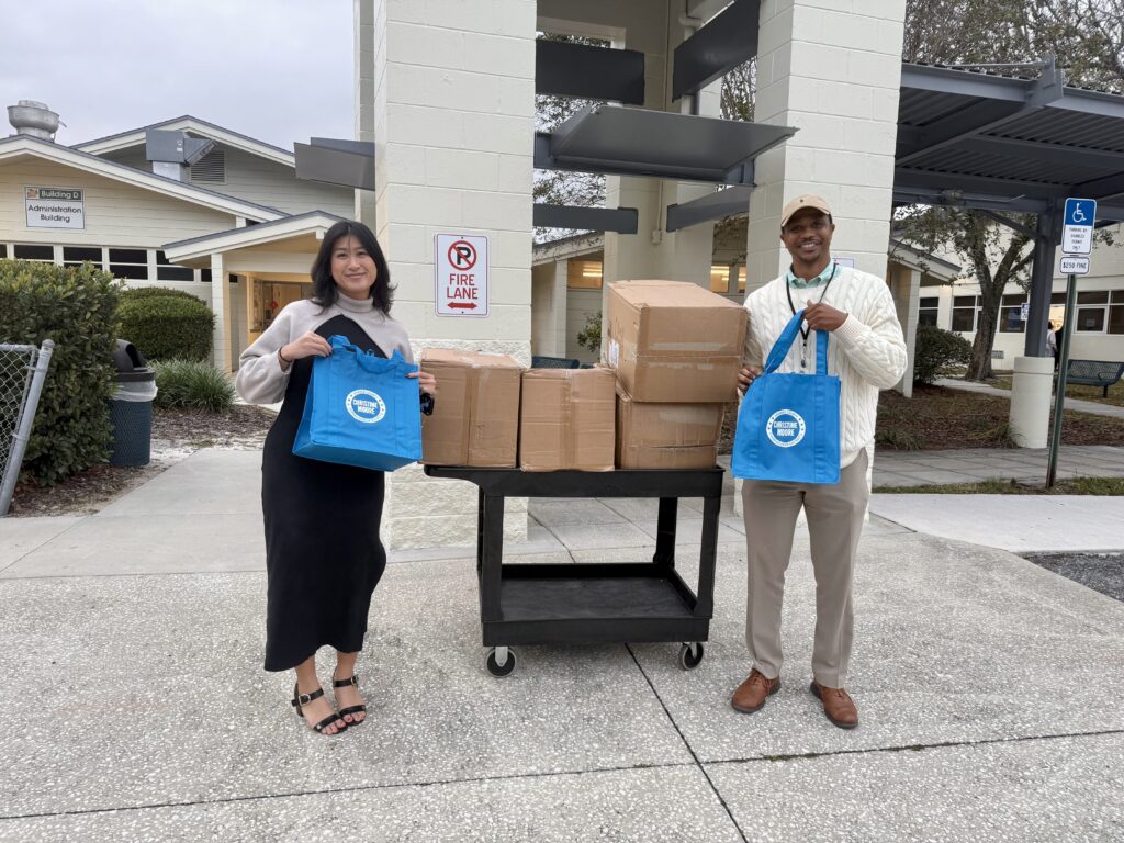 Catherine Le, aide for Commissioner Christine Moore, and John Latimer Jr. pose with bags for the giveaway.