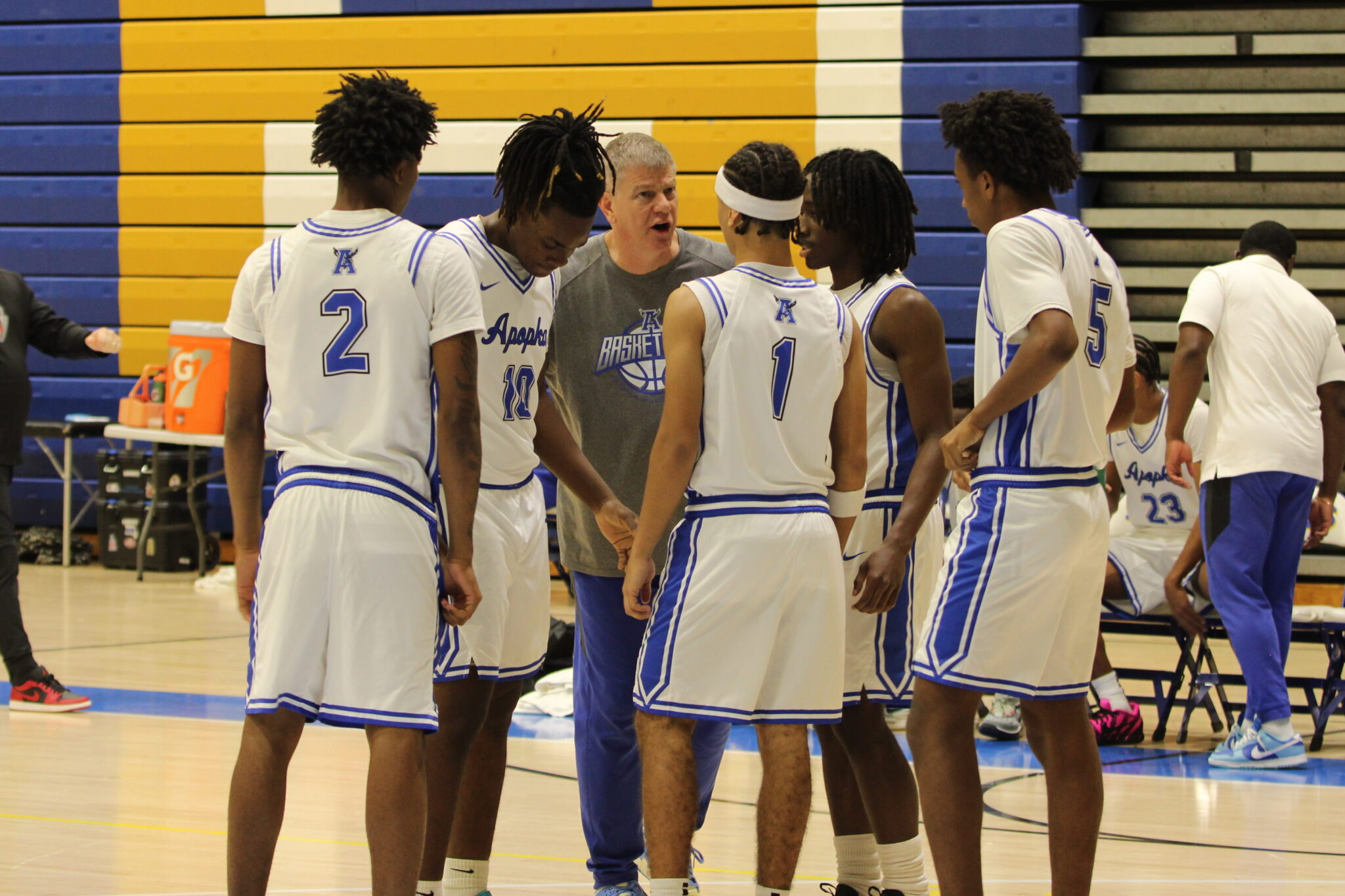 Coach Scott Williams gathers his starting lineup before tipoff