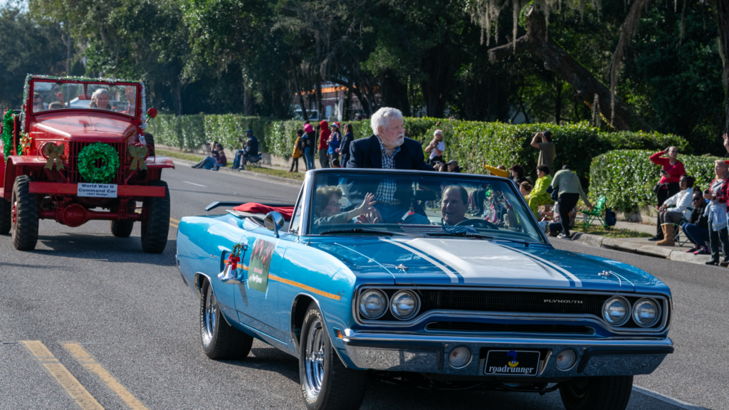 Grand Marshal Tom Dorman rides in a blue Chrysler Plymouth.