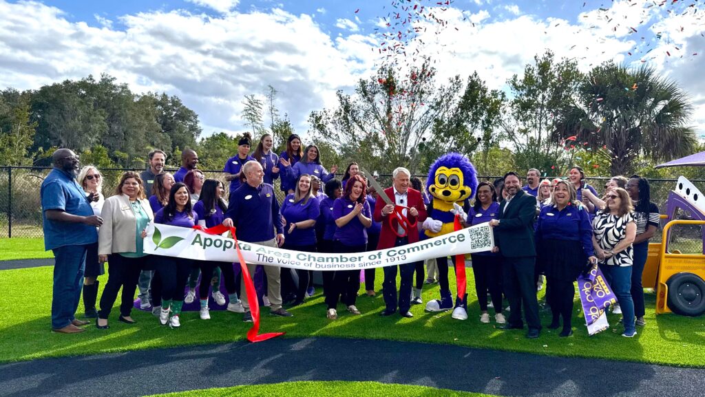 Mayor Bryan Nelson cuts the ribbon at O2B Kids' ribbon-cutting ceremony in the playground.