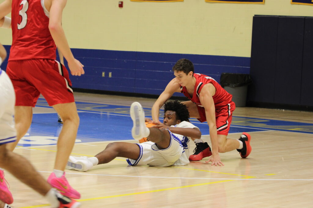 Noah Ferrer dives and beats a Knight to the ball