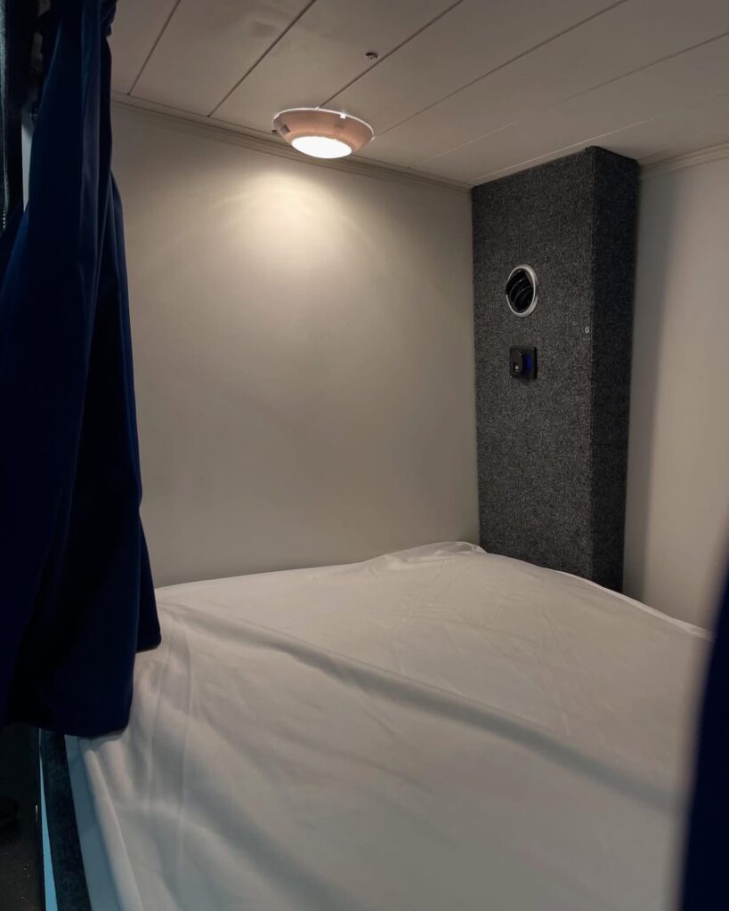 A bed inside a sleeper bus comes with a high-quality mattress, individual climate controls, lights and power outlets for charging phones.