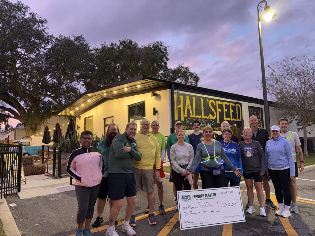 The Apopka Run Club poses with a DICK'S Sporting Goods check at its Dec. 9 meetup.