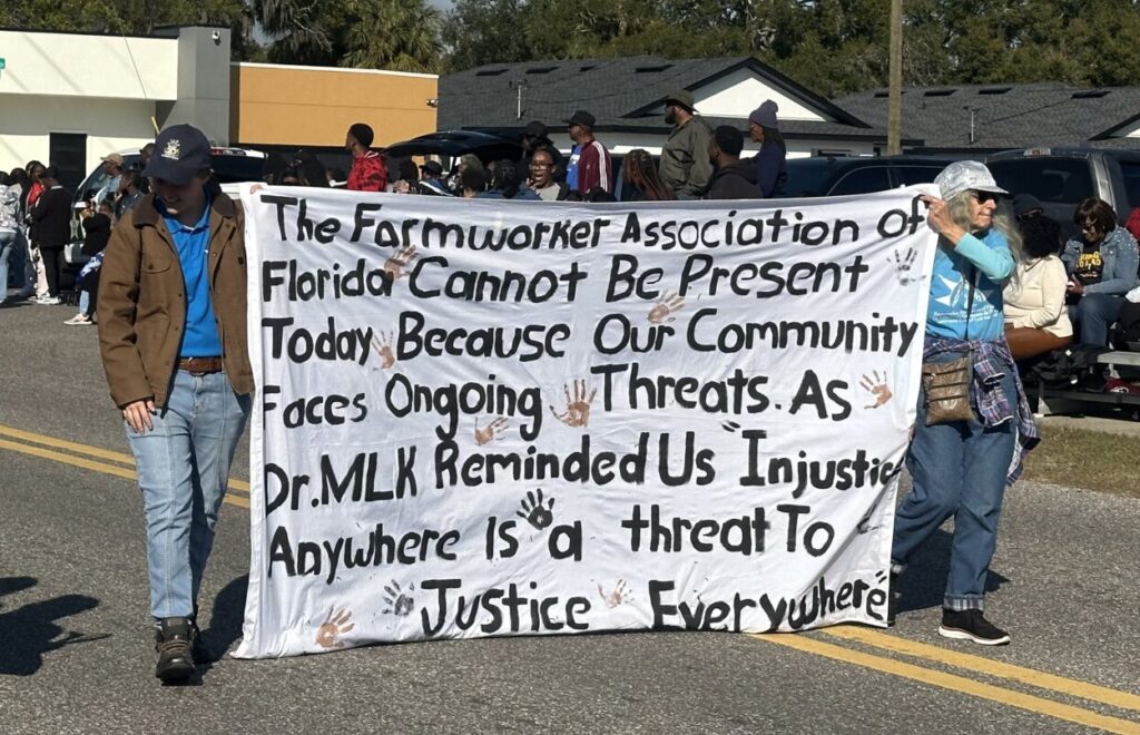 Members of the Farmworker Association of Florida march down Marvin C. Zanders Avenue in Apopka during Monday’s 17th annual Martin Luther King Jr. Parade, carrying a banner honoring the civil rights leader.
