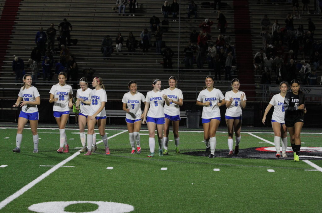 Lady Blue Darters run off the field after the National Anthem