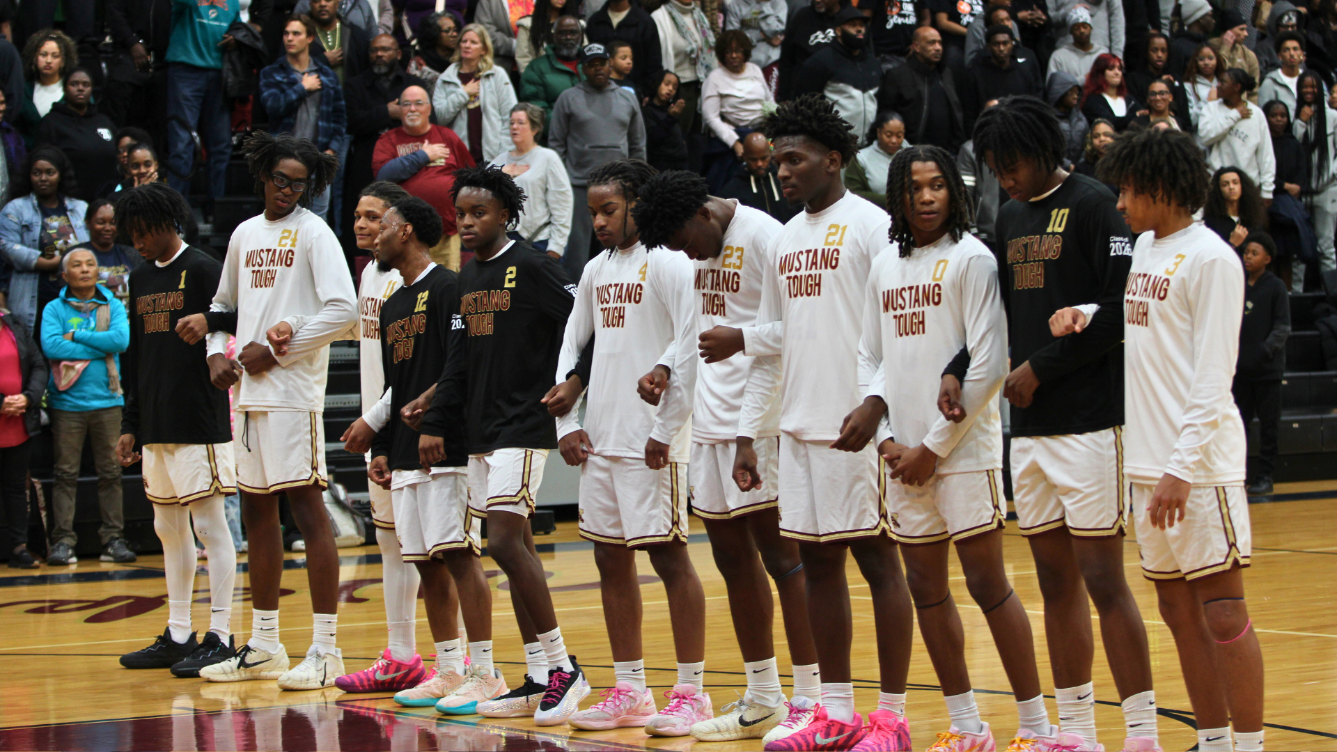 Mustangs lock arms for the National Anthem ahead of senior night