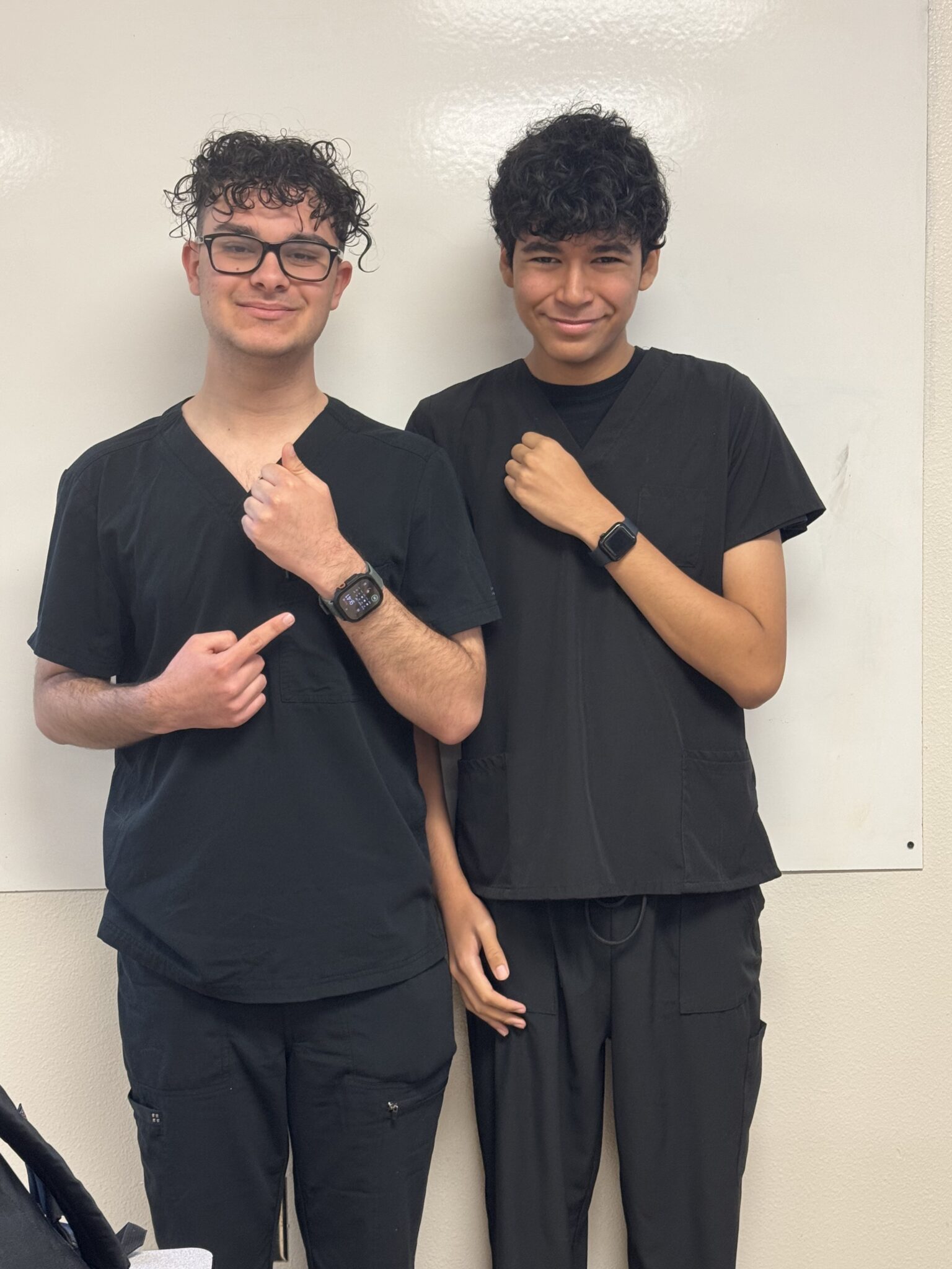 Thomas Perez and one of his teammates show off smart watches.