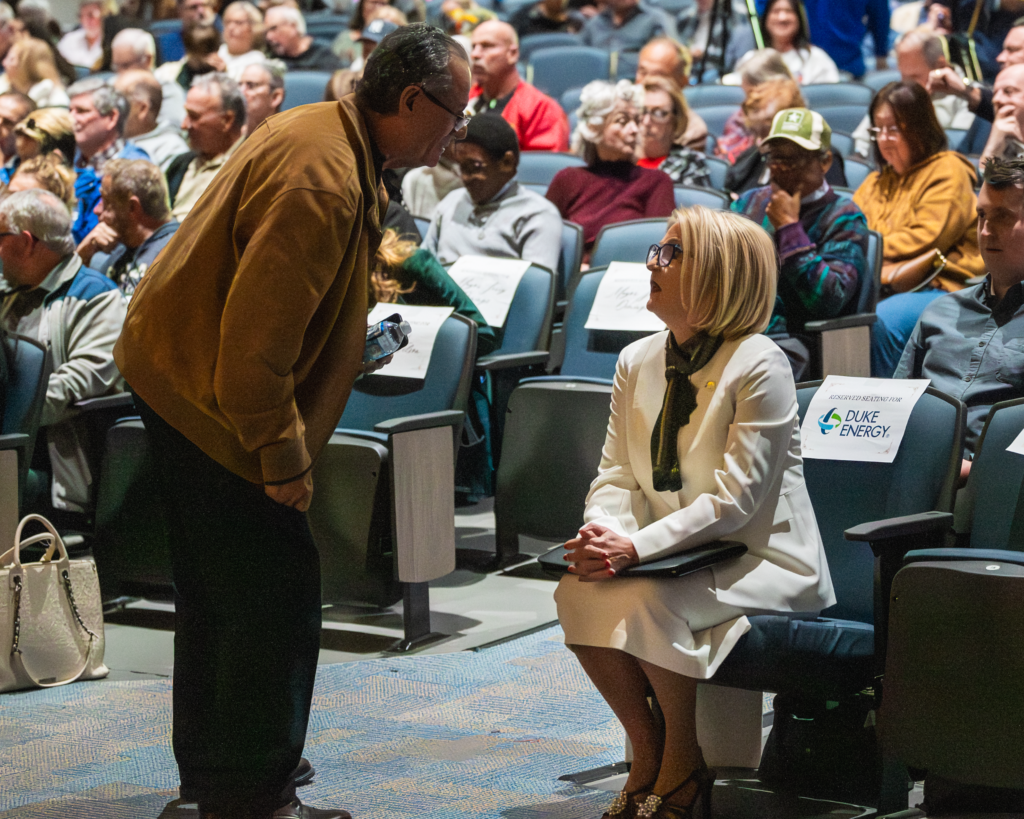 Commissioner Christine Moore speaks with an attendee at the Feb. 3 mayoral debate.