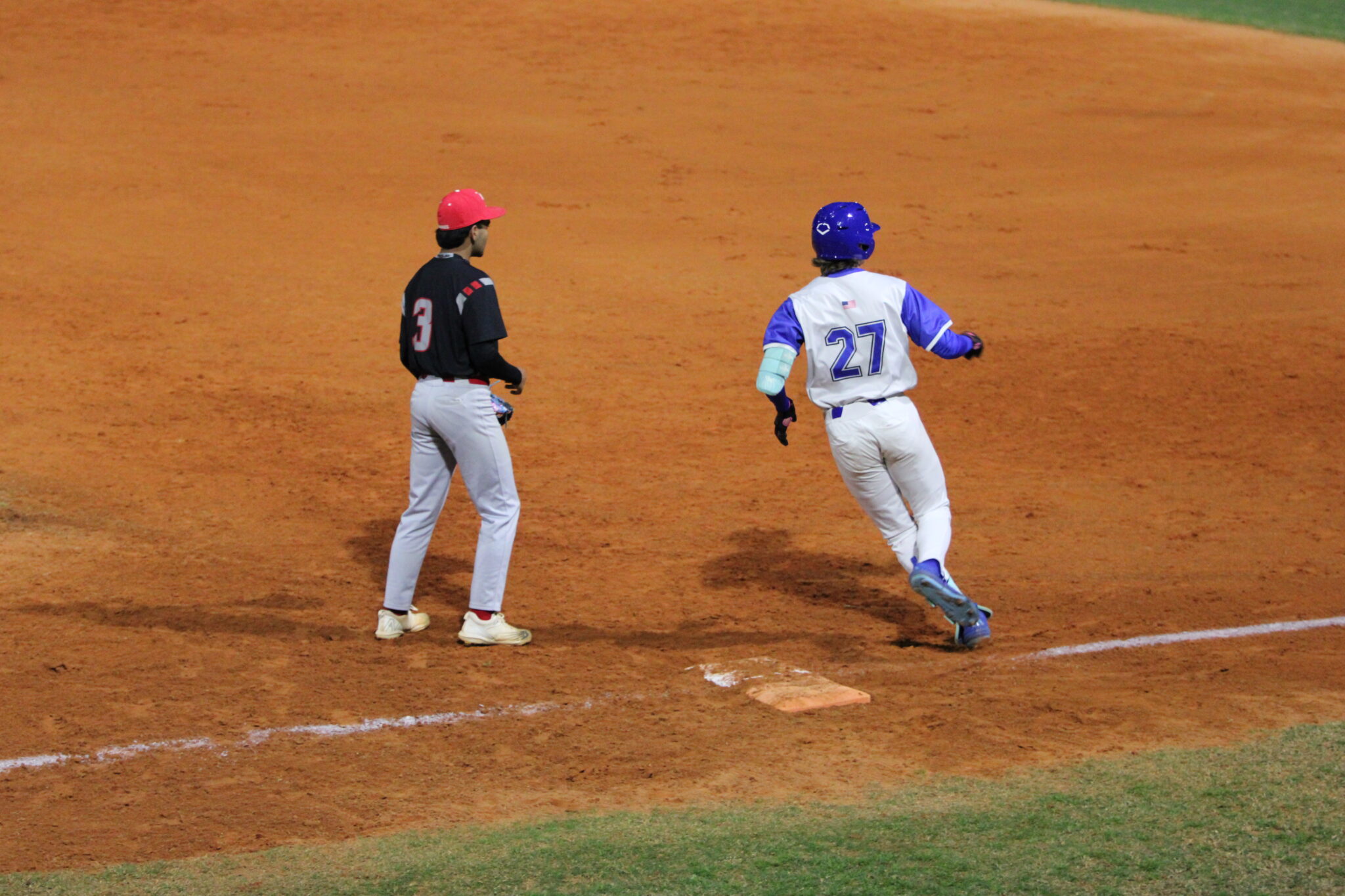 Camron Pennock rounds first base as he watches the right fielder with the ball