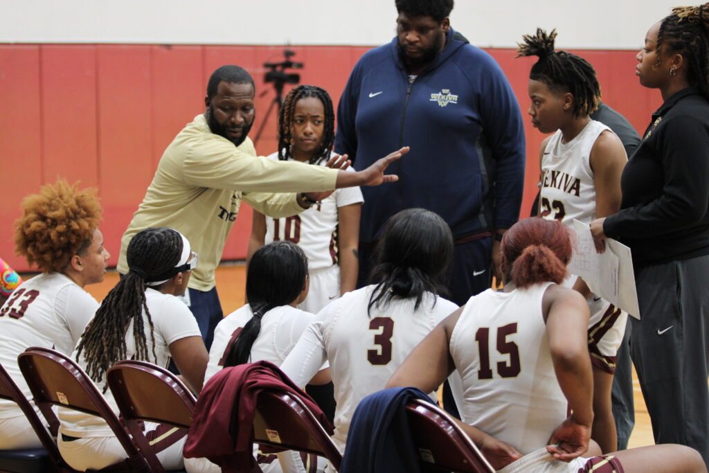 Coach Jerry Middleton game planning with the girls during a full timeout late in the game