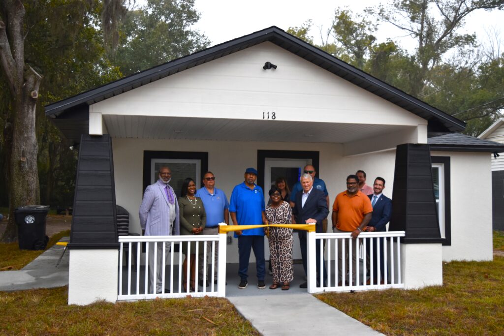 The Griffins pose in front of their new home with representatives from the city of Apopka.