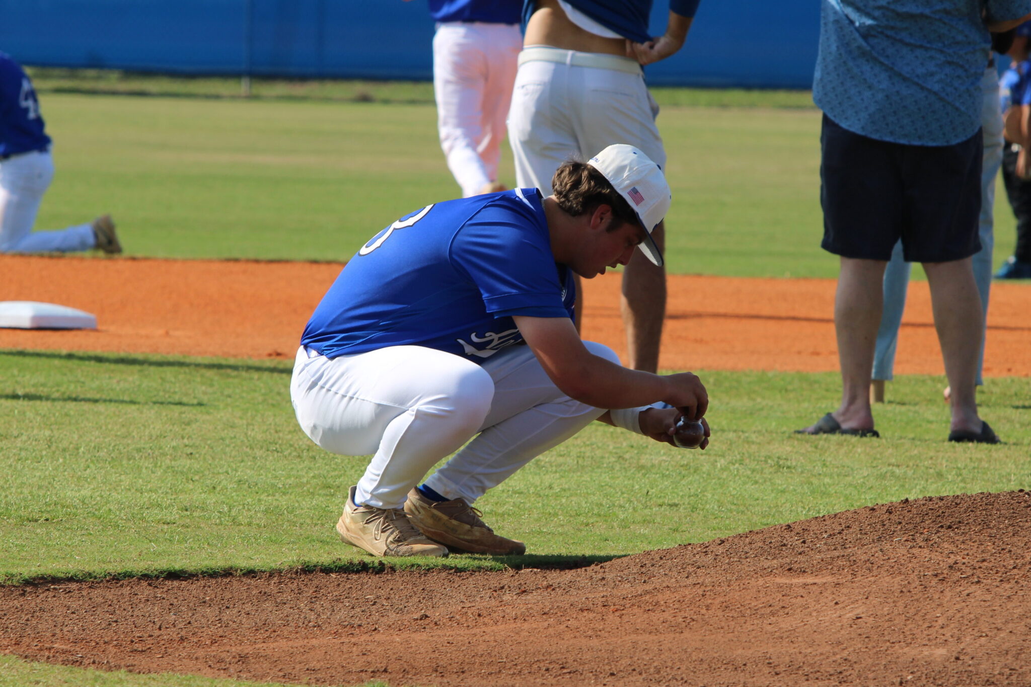 Anthony Raymond collects dirt from the mound he pitched on