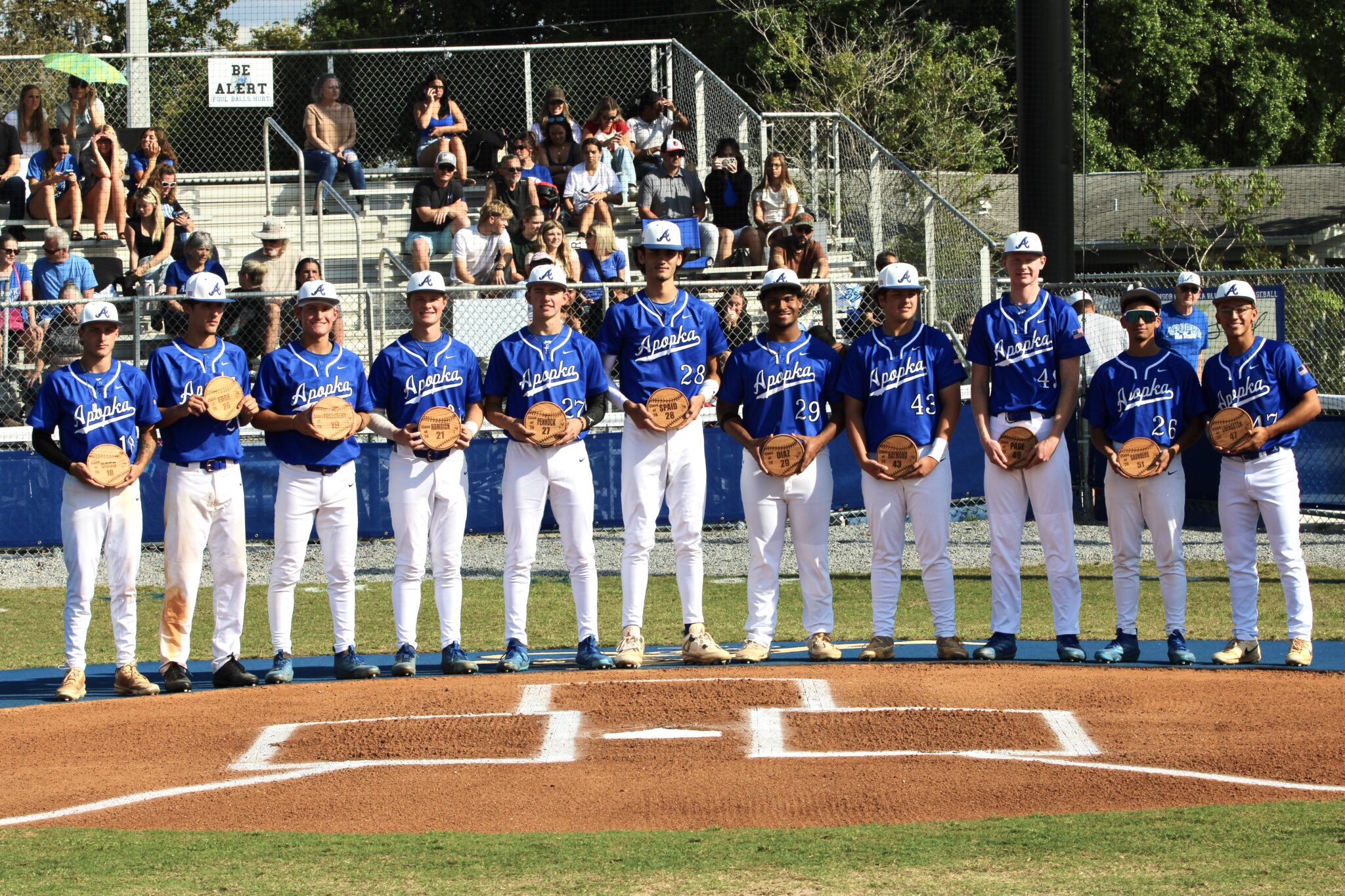 Apopka baseball seniors pose with their memorial plaques on senior night