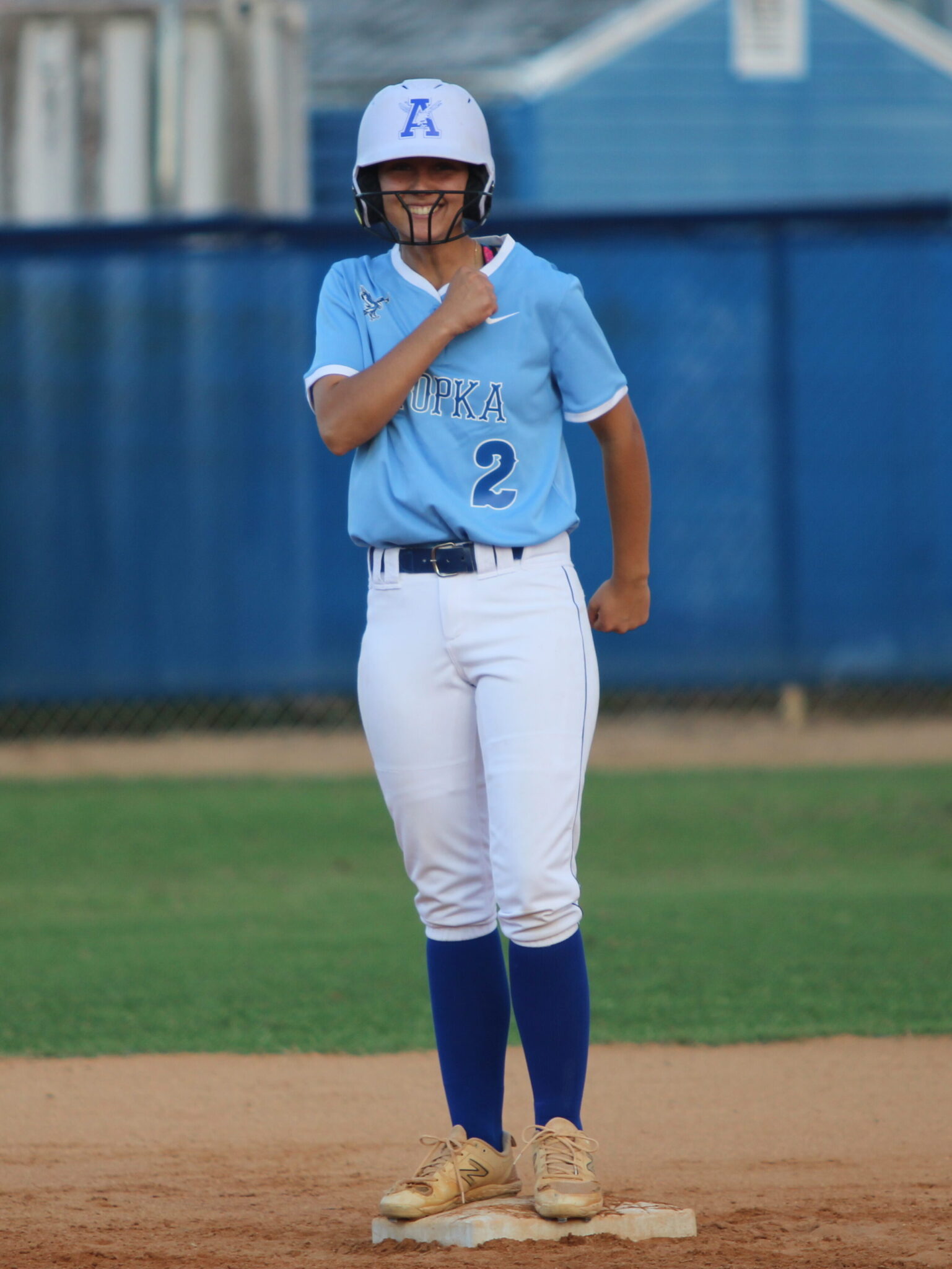 Ava Gonzalez flexes to the joy of her dugout after her double scores their third run