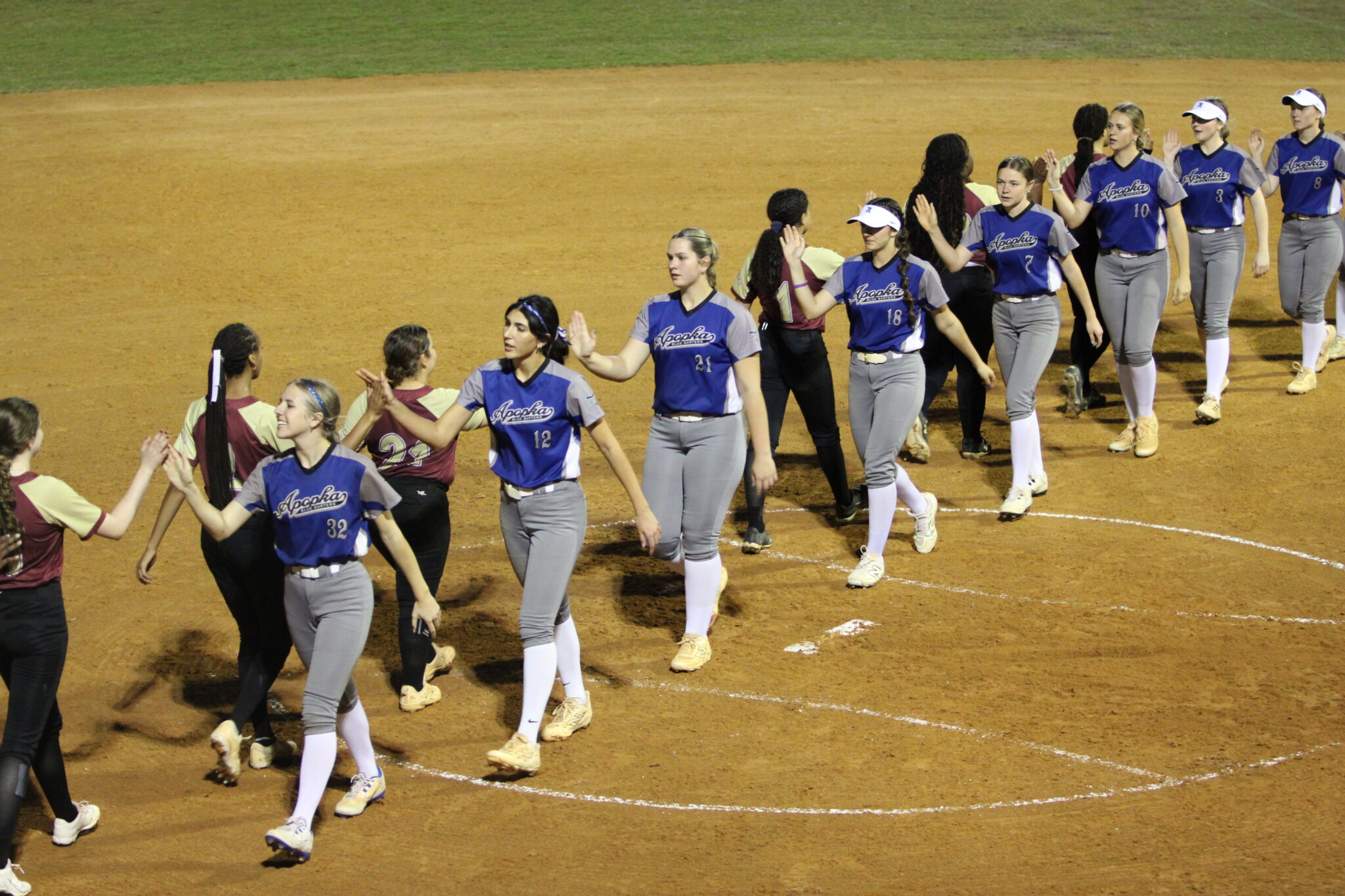 Blue Darters and Mustangs line up and shake hands after three innings