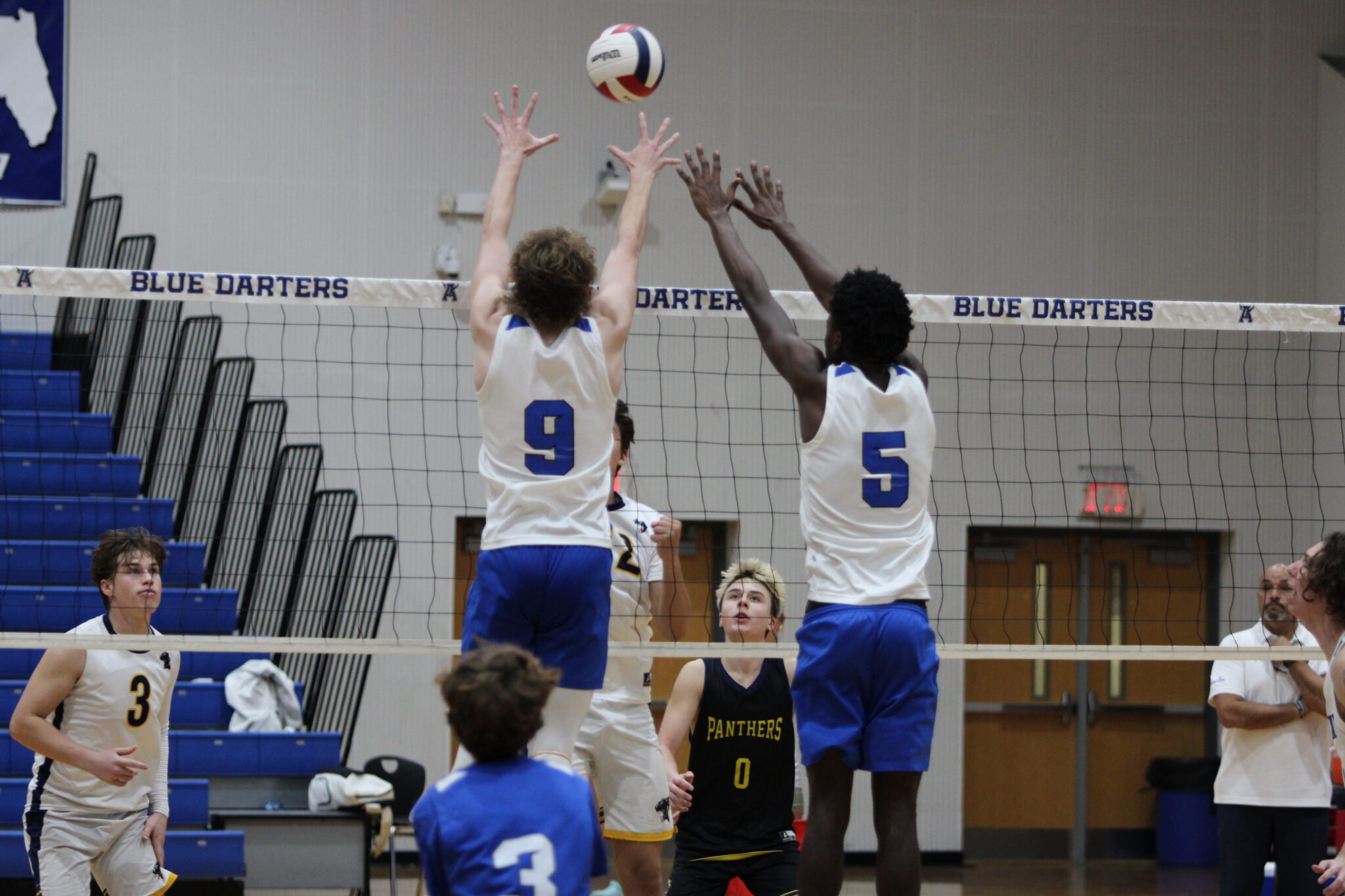 Caden McGatha and Giovanni Lubin rise up at the middle of the net in attempt to block the Forest Lake Academy kill